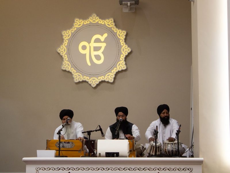 Kirtan in the Darbar Hall, beneath the Ik Onkar